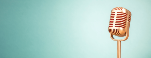 A retro microphone sits on a pale ultramarine background
