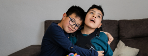 A boy hugs his disabled brother