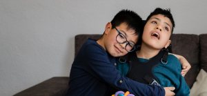 A boy hugs his disabled brother