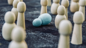 Several wooden pins stand upright. One lone blue pin lies on its side.