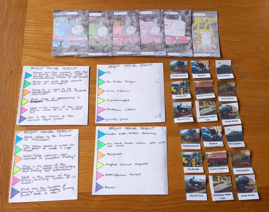 A selection of home made board game pieces, with a train theme