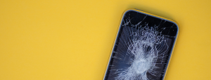 smart phone with a cracked screen, on a yellow background