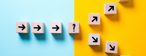 Split blue and yellow background, with several blocks with arrows on them that split into two directions.
