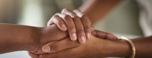 A pair of hands clasp another in support