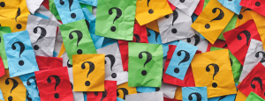 Green, yellow, red, white and blue sticky notes with question marks on them scattered across the page completely filling it