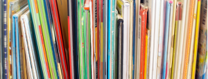 Edges of thin and colourful books lined up next to each other